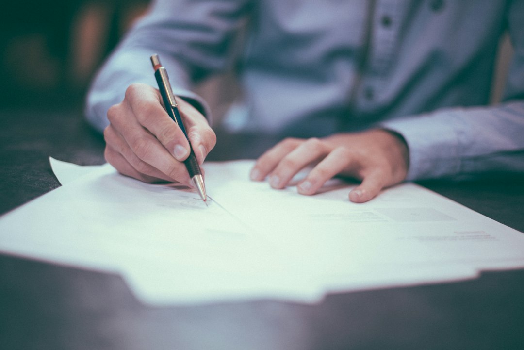 Personne signant un document avec un stylo
