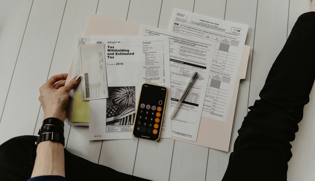 Personne tenant un document à côté d'un stylo et d'une calculatrice